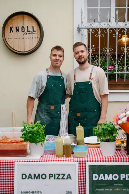 Pizzaioli DAMO v zelených zástěrách u stánku před kavárnou Knoll